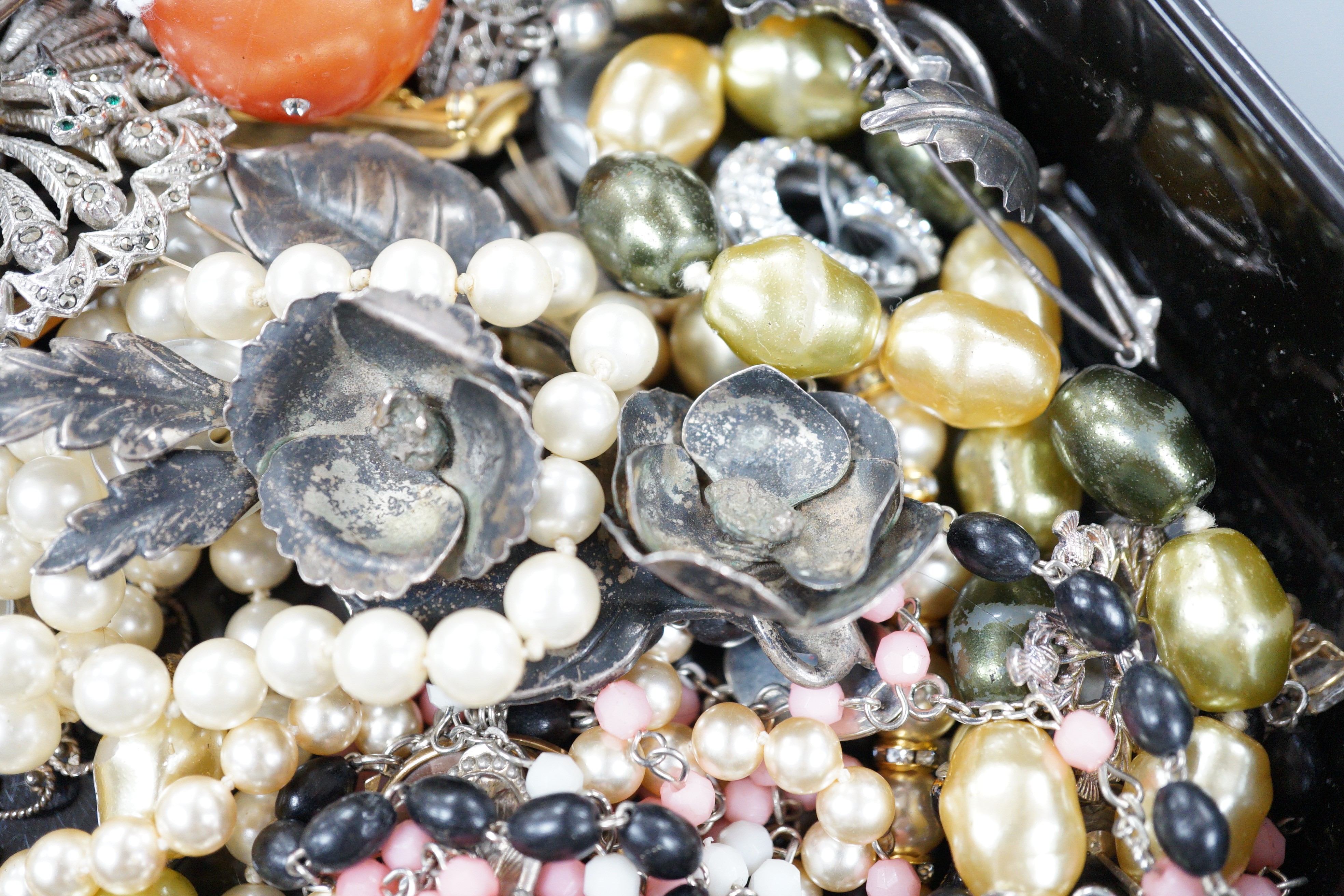 A quantity of assorted costume jewellery in a lacquer box.